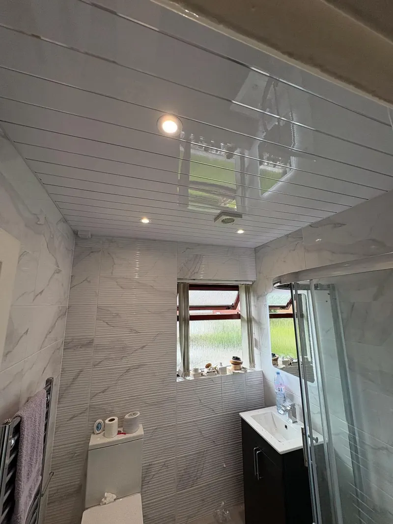 Bathroom ceiling in white gloss panelling with new spotlights and an extractor fan